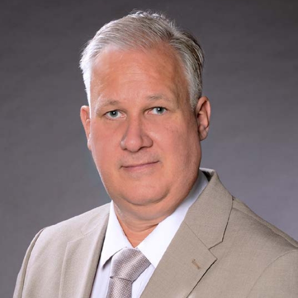 Portrait-Michel-Mentschke-MERTZ Herr Mentschke trägt einen hellen Anzug mir Krawatte und schaut freundlich in die Kamera. Man sieht den Kopf und die Schultern.
